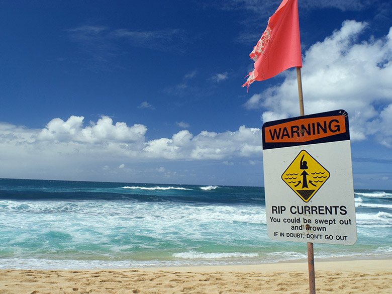 beach closed warning sign on hawaiis north shore, sunset beach